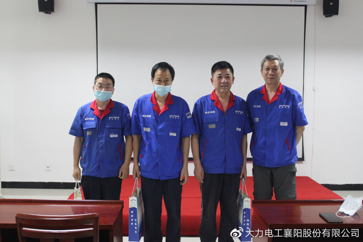 图为任总为生产中心协作人员颁发礼品并合影留念